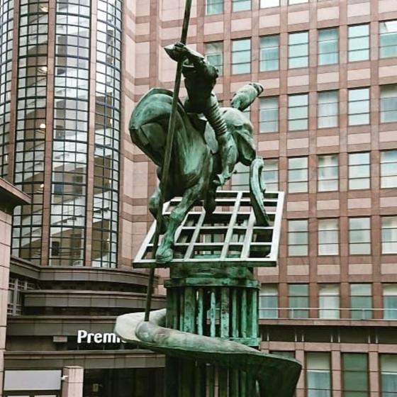 Man on a horse attacking a harmless dragon